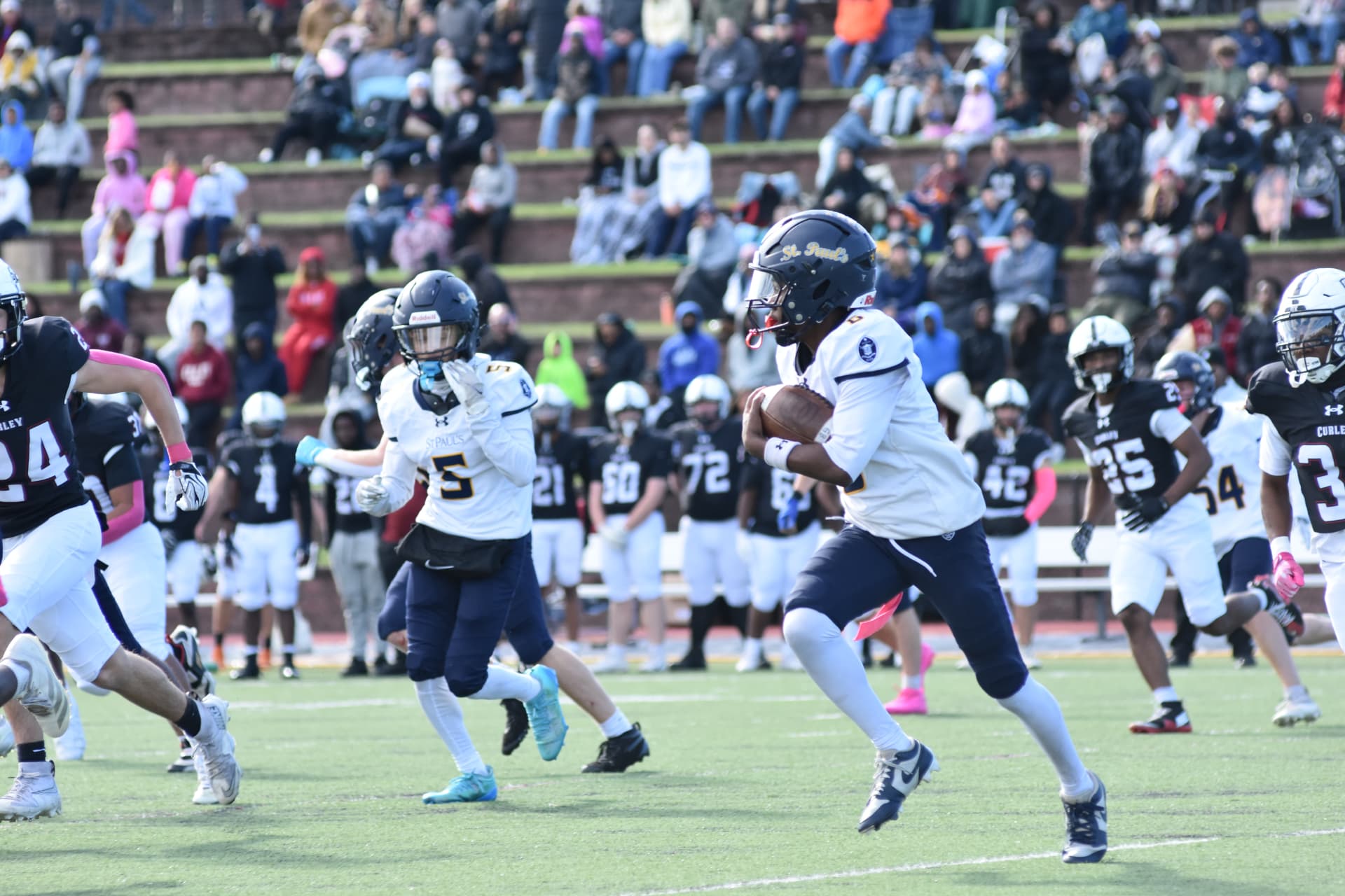 A Crusader carries the ball upfield with a teammate alongside him