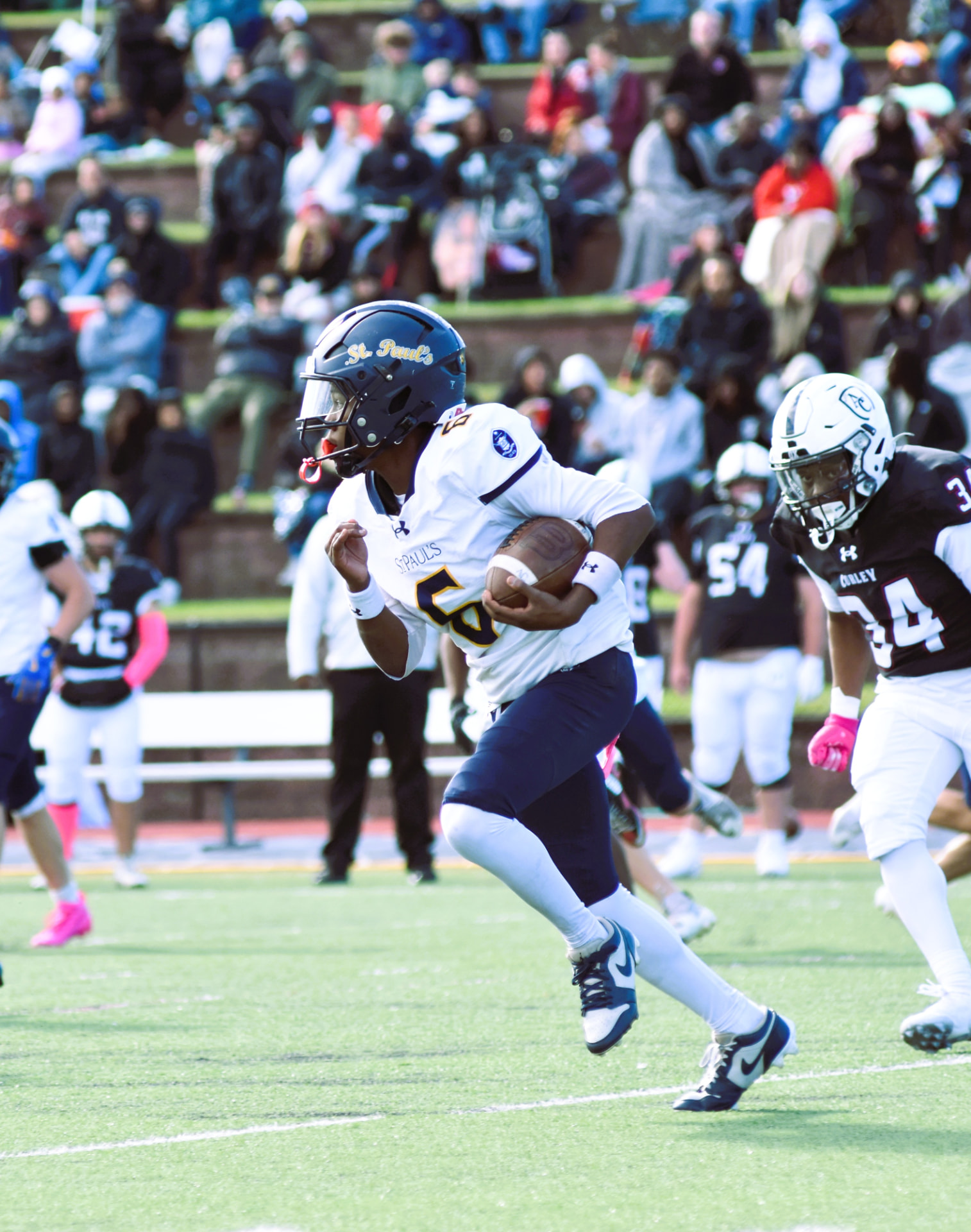 Crusaders number 6 runs with the ball ahead of a Curley defender