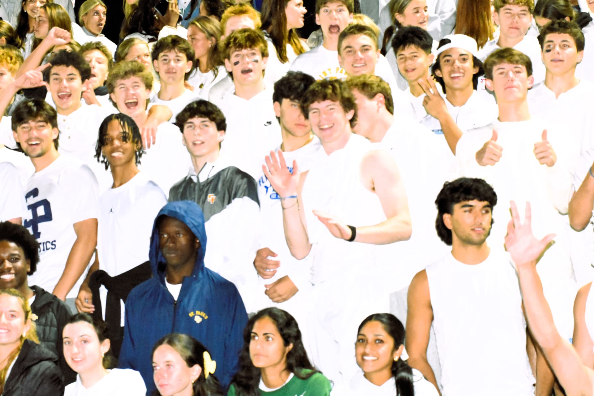 The student section celebrates in white