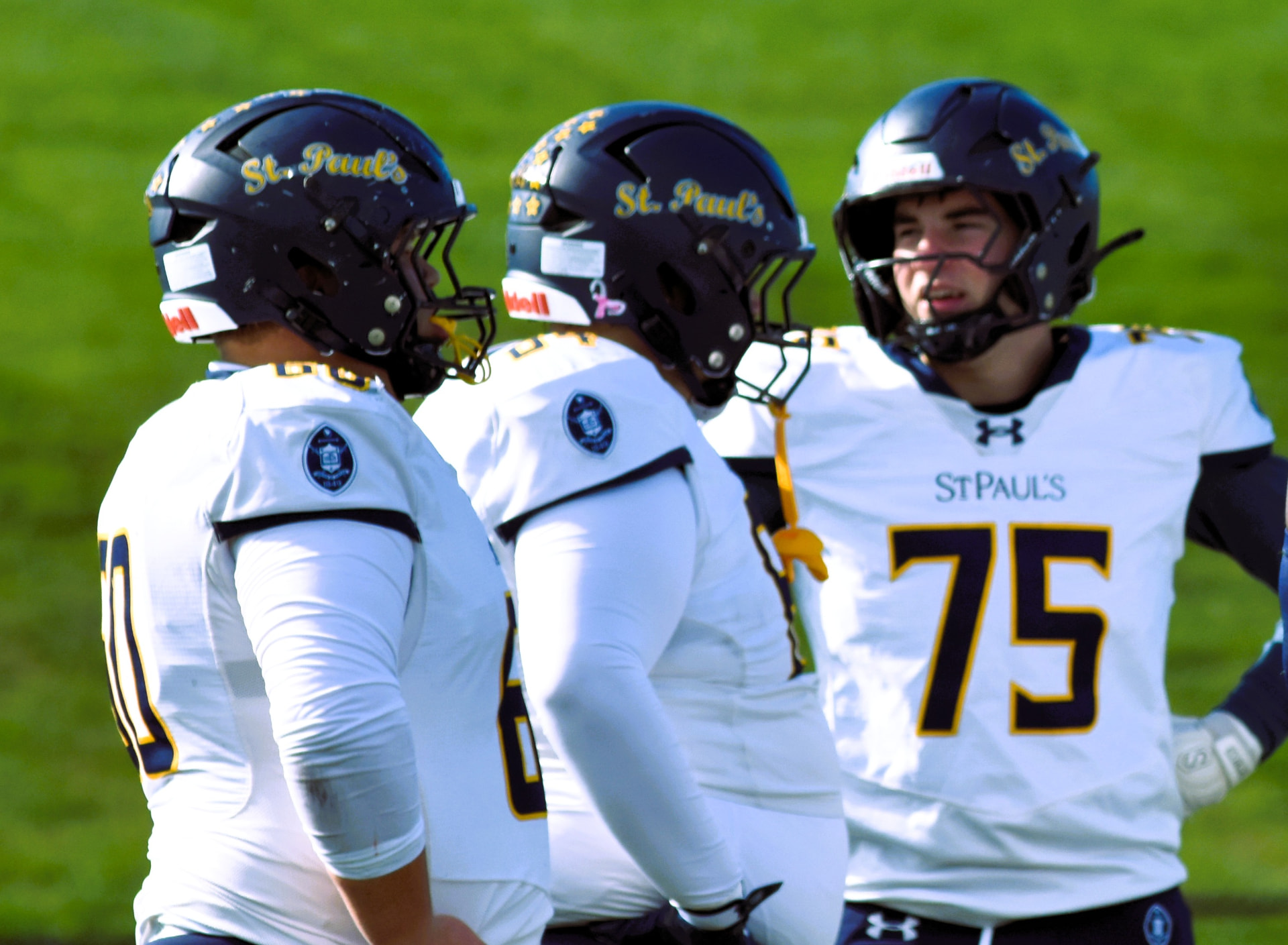 Crusaders linemen gather on the field with number 75