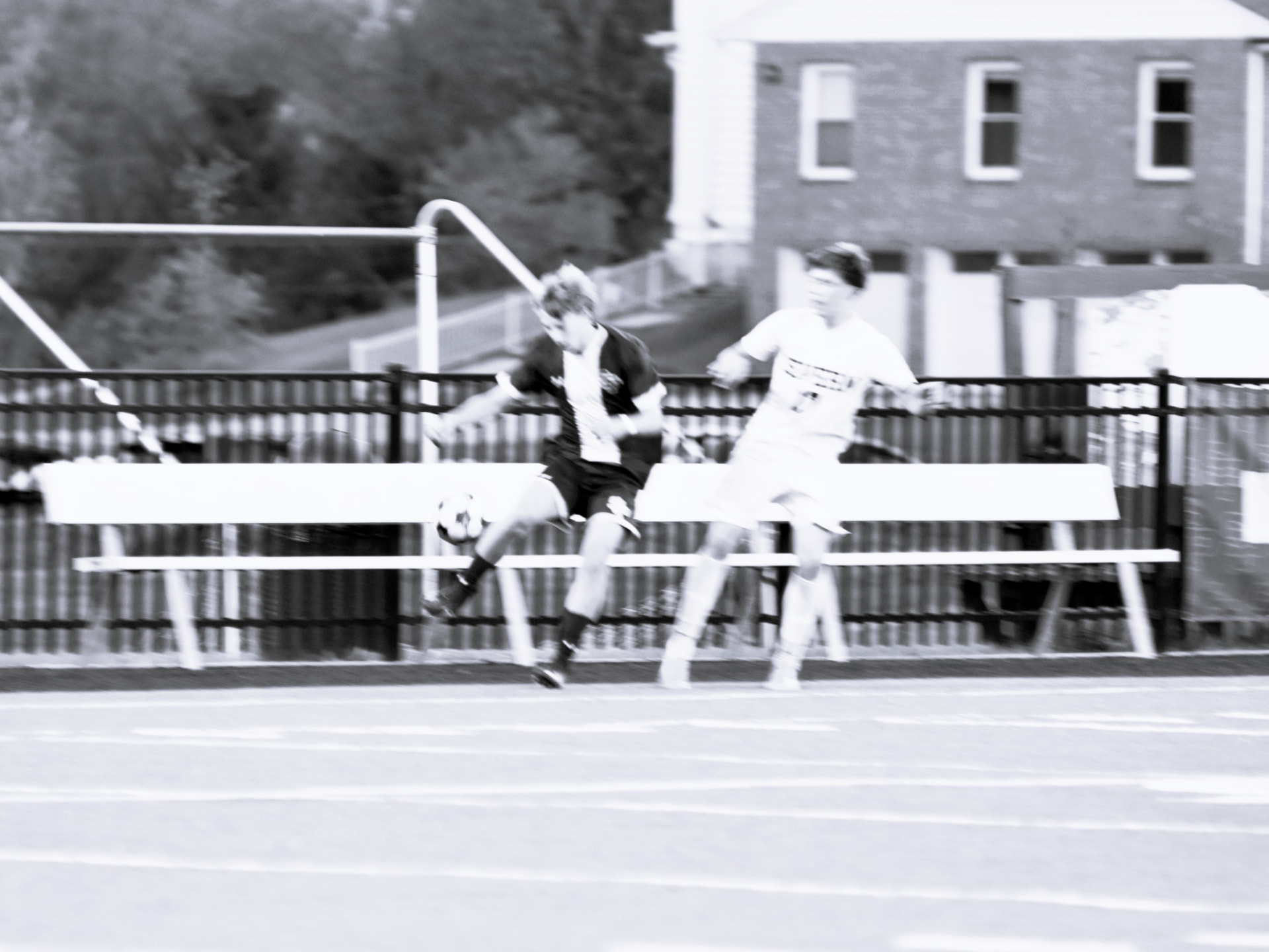 Players contest the ball in a black-and-white action photo