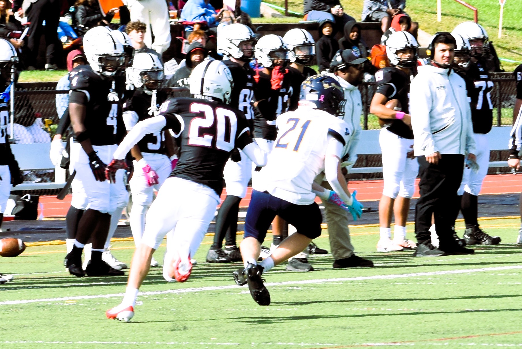 Crusaders number 21 runs alongside Curley number 20 near the sideline